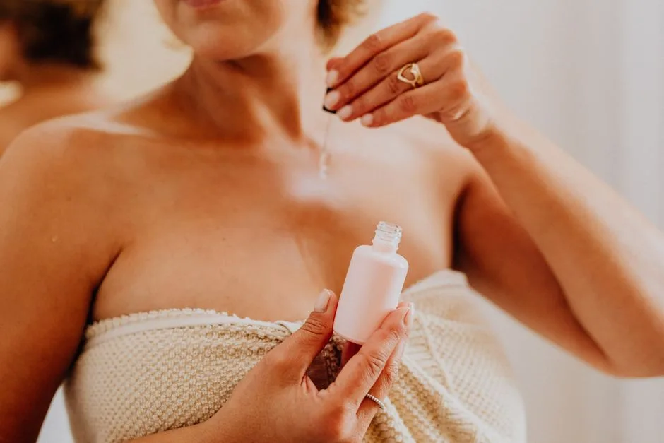 Close-up of a woman applying serum to her skin, enhancing beauty routine.
